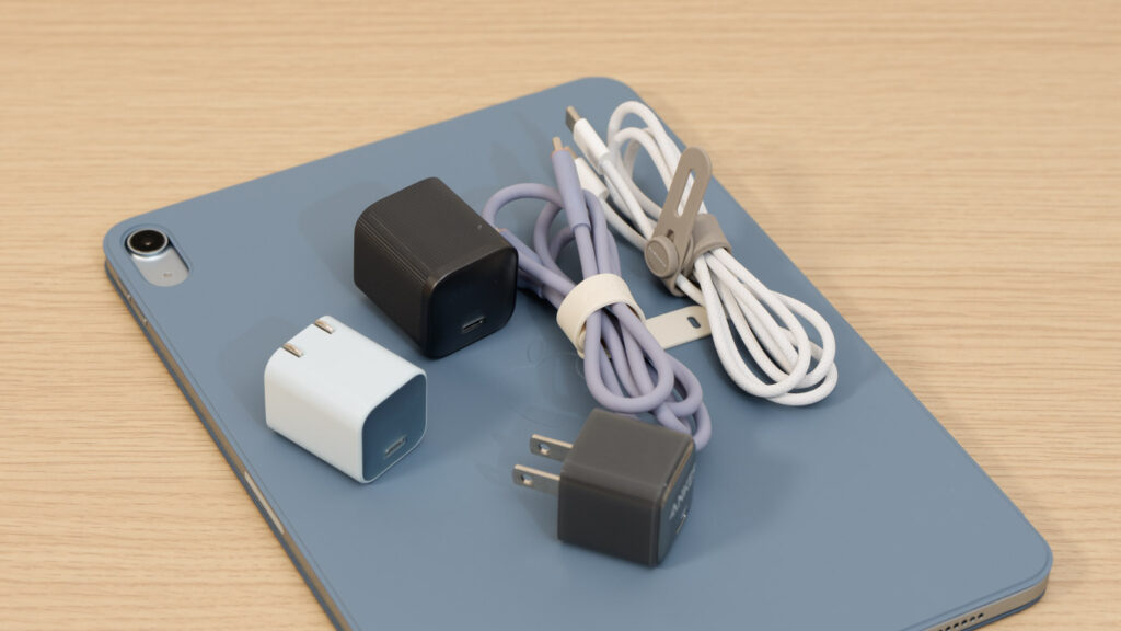 iPadと複数の充電器とケーブル