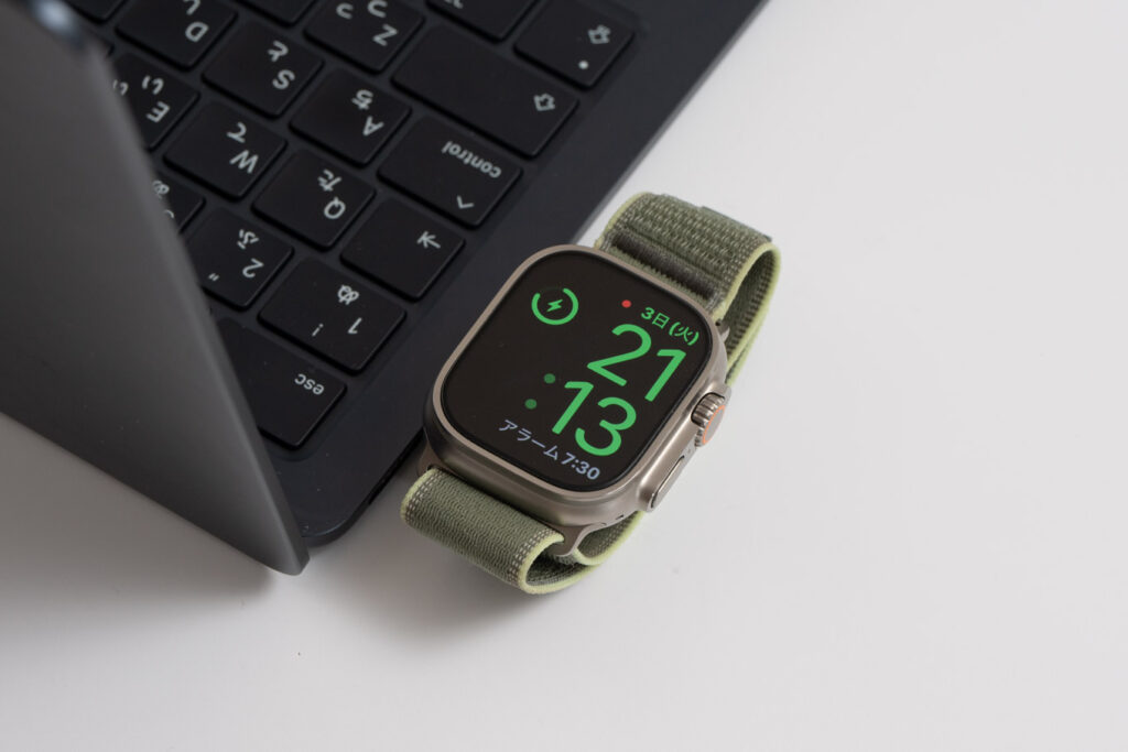 Belkin BoostCharge ポータブルUSB-C Apple Watch充電器をMacBook Airに接続し、Apple Watch Ultra 3を充電している様子