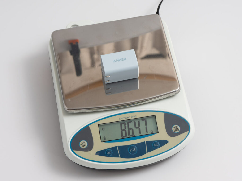 スケールの上にAnker 523 Chargerを載せて計測している様子。表示は86.47g。