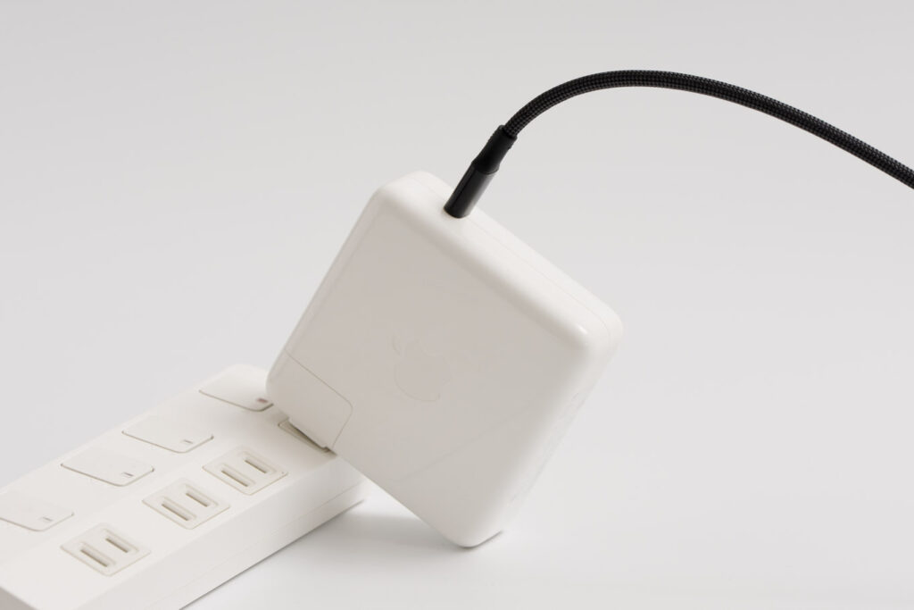 Apple 96W USB-C電源アダプタを電源タップに接続している様子